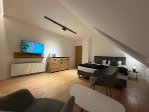 a bedroom with a bed and a flat screen tv at Klakierówka in Piechowice