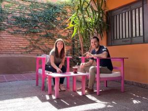 a man and a woman sitting at a table at Refugio - Suite privada con jardín y parrilla en Chilecito in Chilecito