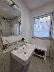 a white bathroom with a sink and a mirror at Zippel`s Fewo M14 in Bad Buchau
