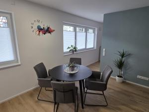 a dining room with a table and chairs and a clock at Zippel`s Fewo M14 in Bad Buchau