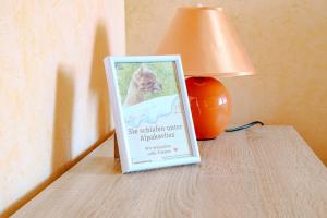 a sign sitting on a table next to a lamp at Ferienwohnung 2 "Zum Feld" auf dem Alpakahof in Bernstadt