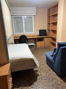 a bedroom with a bed and a desk and a window at ApartamentosAlquilerZaragoza in Zaragoza
