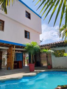 a house with a swimming pool in front of a house at Hotel Piedra del Mar in Puerto López
