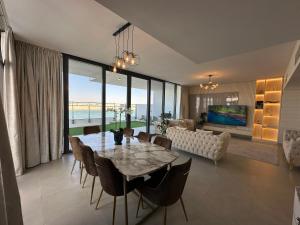 ein Esszimmer mit einem Tisch und einem Sofa in der Unterkunft Beachfront Villa with Heated Private Pool & Jacuzzi in Al Ḩamrīyah