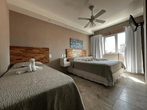 a bedroom with two beds and a ceiling fan at Hotel Rideamus in Villa Gesell +73 photos