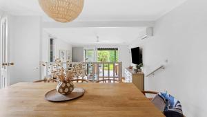 a dining room with a wooden table with a vase on it at Waves on Rye in Rye +22 photos
