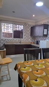 a kitchen with a table with a leopard patterned table cloth on it at Sea View Haven in Accra