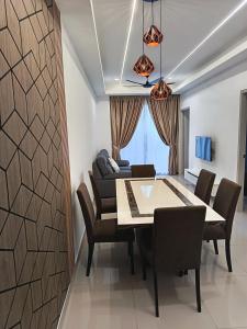 a dining room with a table and chairs and a couch at Piccadilly Residence by LMS ipoh in Ipoh