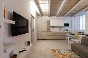 a living room with a couch and a tv on the wall at Cà del Lago in Arona