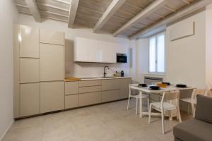 a kitchen with white cabinets and a table and chairs at Cà del Lago in Arona
