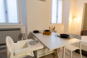 a white kitchen with a white table and chairs at Cà del Lago in Arona