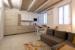 a living room with a couch and a kitchen at Cà del Lago in Arona