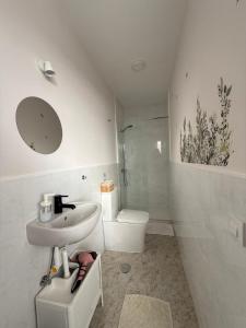 a white bathroom with a sink and a toilet at Casa Ángel 1982 in Oia +43 photos