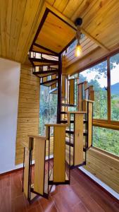a room with wooden walls and a large window at Riverfront Paradise Villa River front Villa in Jarabacoa