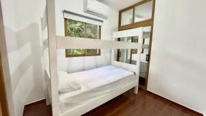 a small bedroom with a bunk bed with a window at Riverfront Paradise Villa River front Villa in Jarabacoa