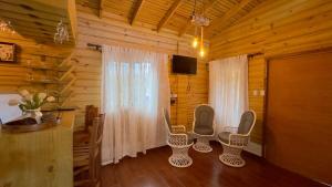 a room with chairs and a table in a cabin at Riverfront Paradise Villa River front Villa in Jarabacoa