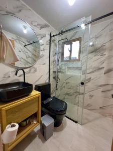 a bathroom with a toilet and a glass shower at Riverfront Paradise Villa River front Villa in Jarabacoa +49 photos