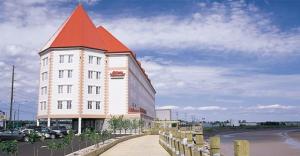 a large white building with a red roof at Chateau Moncton Trademark Collection by Wyndham in Moncton