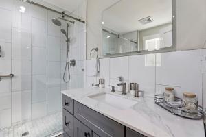 a white bathroom with a sink and a shower at Angie Oasis Yard, Loft & Stocked Kitchen in San Ramon +23 photos