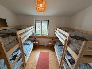 a room with three bunk beds and a window at Algarve Surf Hostel & Guest House in Raposeira