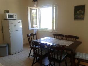 a kitchen with a table and chairs and a white refrigerator at Apartment Dora in Splitska