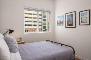 a bedroom with a bed and a window at Luxury Downtown 2 Bedroom Flat in Neenah