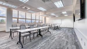a classroom with tables and chairs in a room with windows at University Inn in Logan