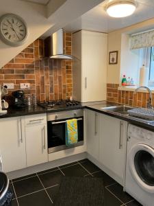 a kitchen with a stove and a dishwasher at Meadow Cottage in Crieff