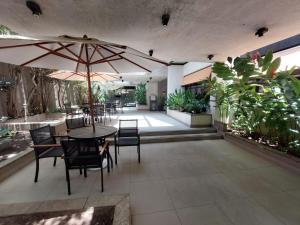 a patio with a table with chairs and an umbrella at Flat Jardins, Paulista, Oscar Freire, restaurantes in São Paulo