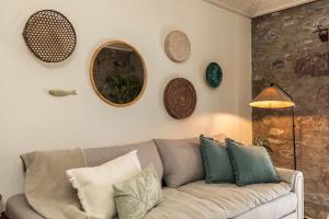 a living room with a couch and mirrors on the wall at Casinha da Vereda by Rent-a-key in Paul do Mar
