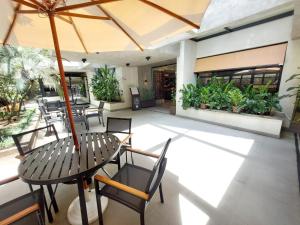 a patio with a table and chairs and an umbrella at Flat Jardins, Paulista, Oscar Freire, restaurantes in São Paulo