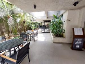 a restaurant with tables and chairs and palm trees at Flat Jardins, Paulista, Oscar Freire, restaurantes in São Paulo +51 photos