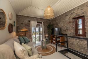 a living room with a couch and a tv at Casinha da Vereda by Rent-a-key in Paul do Mar