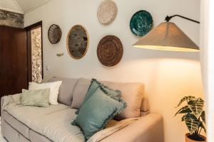 a living room with a couch and plates on the wall at Casinha da Vereda by Rent-a-key in Paul do Mar