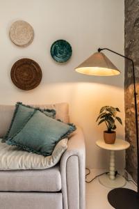 a living room with a couch and a lamp and a plant at Casinha da Vereda by Rent-a-key in Paul do Mar +39 photos