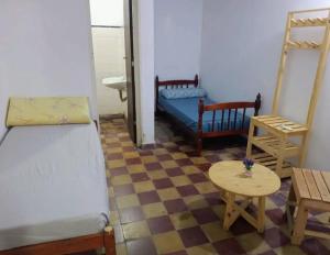 a room with two beds and a table at La casa de Samuel in San Ramón de la Nueva Orán