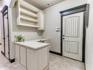 a kitchen with white cabinets and a white door at Spacious Deer Creek Home with Study and Yard in Edmond +21 photos