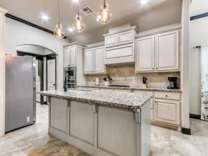 a kitchen with white cabinets and a large island at Spacious Deer Creek Home with Study and Yard in Edmond