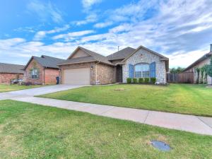 a large brick house with a grass yard at Spacious Deer Creek Home with Study and Yard in Edmond