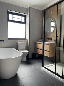 a bathroom with a tub and a toilet and a sink at 12 Banc Pendre in Kidwelly +12 photos