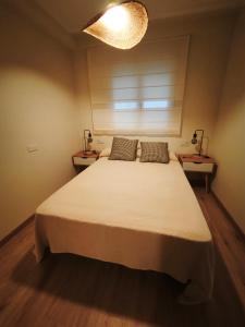 a bedroom with a large white bed with two tables at Aires do Masma in Foz