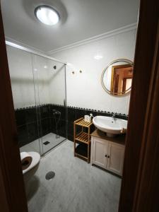 a bathroom with a shower and a toilet and a sink at Aires do Masma in Foz +5 photos