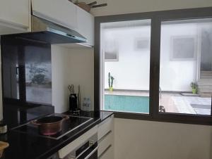 a kitchen with a sink and a pool outside a window at Apartment in Tanger in Tangier