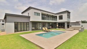 a large white house with a swimming pool at Pops lifestyle in Sandton