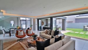 a living room with a couch and chairs and a table at Pops lifestyle in Sandton