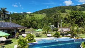 a pool at a resort with a mountain in the background at Villa Sana Maritacas in Sana