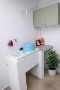 a bathroom with a white sink with a blue seat at leuca house in Lecce