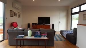 a living room with a couch and a table at SeymourViews Apollo Bay in Apollo Bay