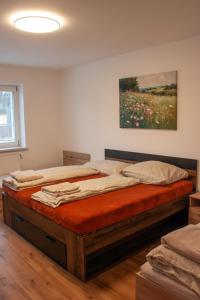 a large bed in a room with a painting on the wall at Apartmán se společným bazénem Zlonice in Zlonice +14 photos