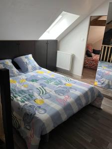 a bedroom with a bed with a colorful comforter at Logement indépendant à la campagne proche du Pôle européen du Cheval et Circuit des 24h du Mans in Courceboeufs